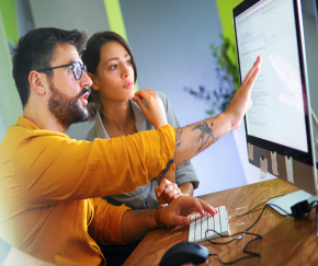 Two individuals looking into a computer screen, checking if the legal compliance for their website.